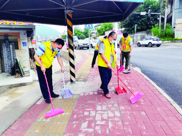     新圩志愿者在清掃道路。  惠州日報記者黃尉宏 通訊員張智軍 攝